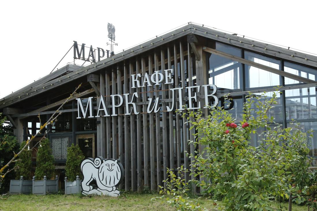 Стеклянное здание кафе «Марк и Лев» с фигурой льва у входа